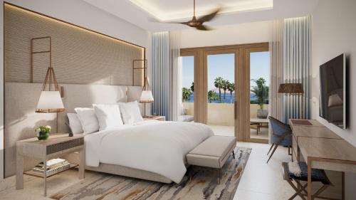a bedroom with a white bed and a desk with a desk at Four Seasons Resort Sharm El Sheikh in Sharm El Sheikh