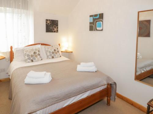 a bedroom with a bed with two towels on it at No 1 Railway Cottages in Betws-y-coed