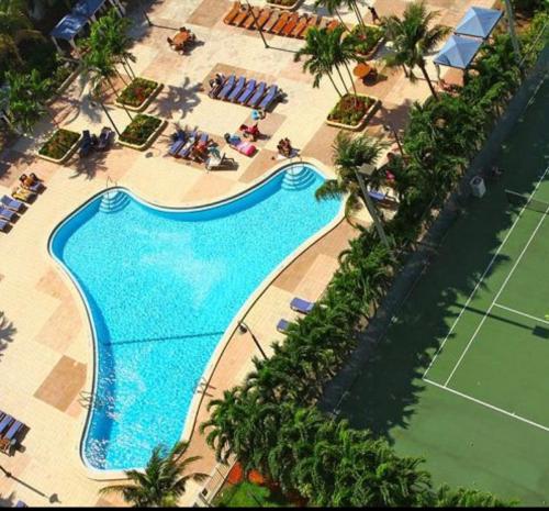 een uitzicht over een zwembad met een tennisbaan bij Miami Sunny Isles ocean reserve 704 in Miami