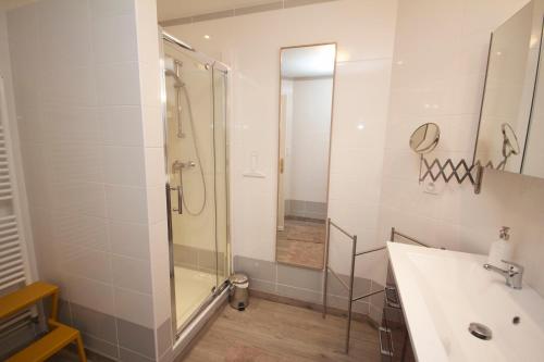 a bathroom with a glass shower and a sink at Moulin de Merzé in Cortambert