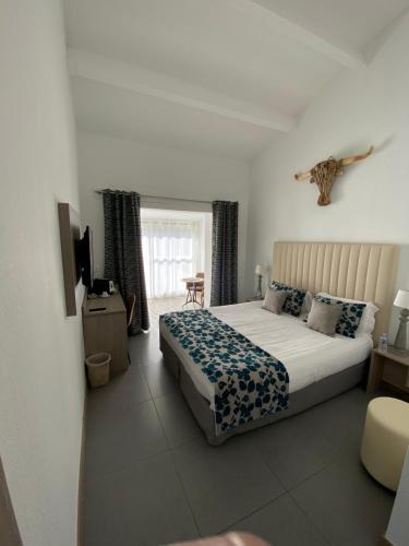 a bedroom with a large bed and a window at Le Mas de Cocagne in Saintes-Maries-de-la-Mer
