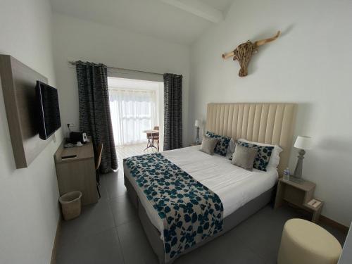 a bedroom with a bed and a television in it at Le Mas de Cocagne in Saintes-Maries-de-la-Mer