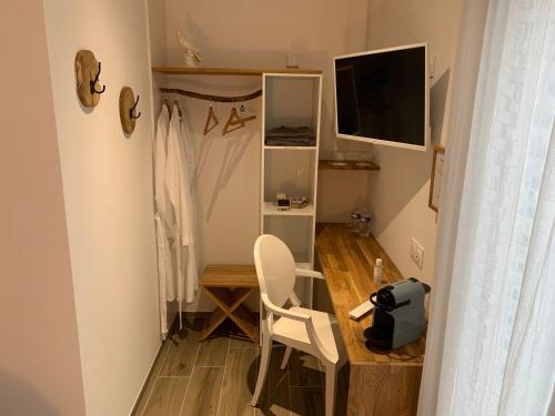 a small room with a desk with a chair and a television at Le patio d'Oscar in Failly