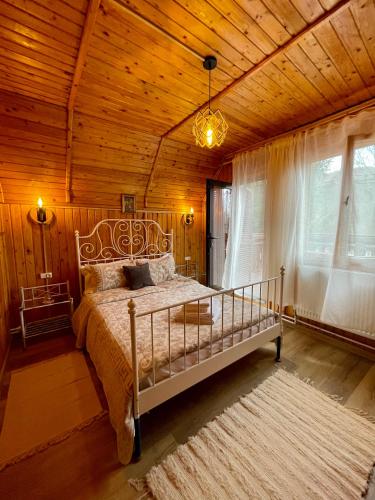 a bedroom with a bed and a wooden ceiling at Cabana din Poveste Valea Doftanei in Trăisteni