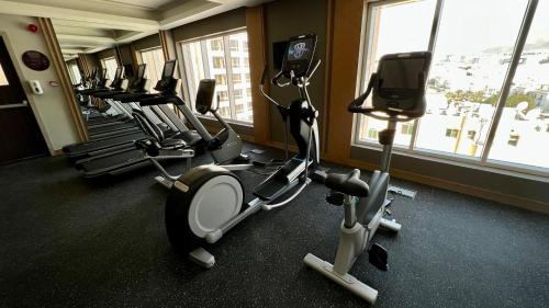 a gym with several treadmills and elliptical machines at Citadines Al Ghubrah Muscat in Muscat