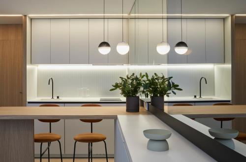 una cocina con mesas de madera, taburetes y luces en 60 Balconies Iconic, en Madrid