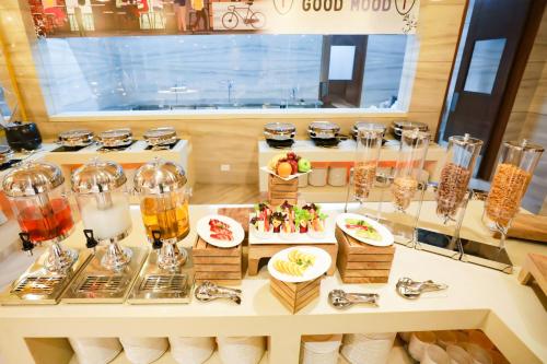 a buffet with glasses and food on a table at Regenta Suites Gurugram, Sector 49 Sohna Road in Gurgaon