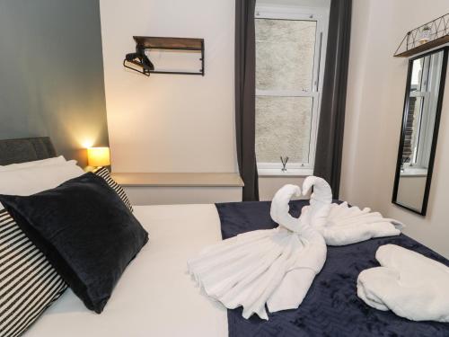 a bedroom with two swans on a bed at Sapphire Suite in Barmouth