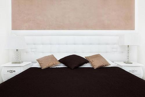 a bedroom with a black bed with two lamps at Town House Fontana Di Trevi in Rome