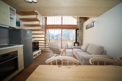 a kitchen and living room with a couch and a table at Villa Alpina Campiglio in Madonna di Campiglio