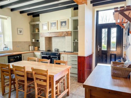 - une cuisine avec une table et des chaises en bois dans l'établissement The Farmhouse, à Whitby