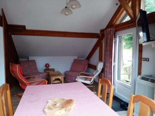 une salle à manger avec une table et des chaises roses dans l'établissement Au grenier du lac, à Gérardmer