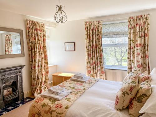 - une chambre avec un lit, une cheminée et une fenêtre dans l'établissement The Farmhouse, à Whitby