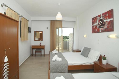 ein Hotelzimmer mit einem Bett, einem Schreibtisch und einem Zimmer in der Unterkunft Panorama Siviris in Siviri