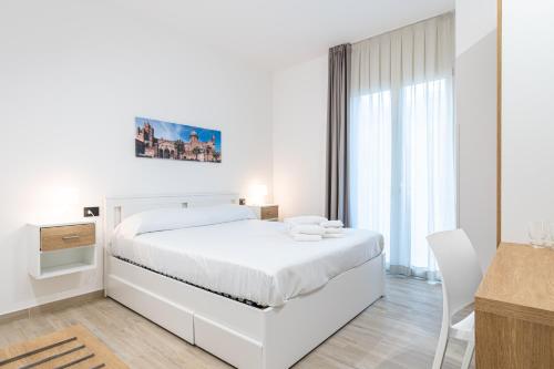 - une chambre blanche avec un lit blanc et un bureau dans l'établissement Palermo Blu - Multi Suite, à Palerme