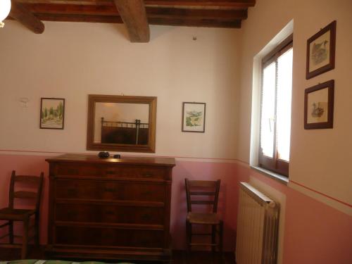 a room with a dresser and a mirror and a window at Ca' le Suore in Cagli