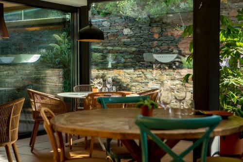 a restaurant with tables and chairs and a stone wall at Hotel Sol Ixent - Adults Only in Cadaqués