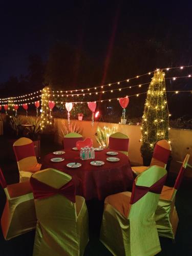 a table with chairs and a christmas tree and lights at The Lalita Grand Mathura- Vrindavan in Mathura