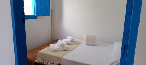 a room with a bed with white towels on it at Casinha do Bem-Viver na Vila de Itaúnas in Itaúnas