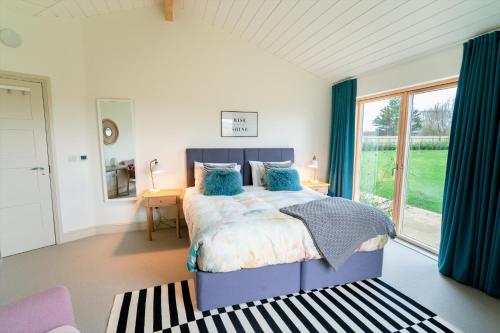une chambre avec un lit et une grande fenêtre dans l'établissement Willow Cottage at Gravel Farm, à Stretham