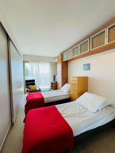 a bedroom with three beds with red sheets at Floriana in Cannes
