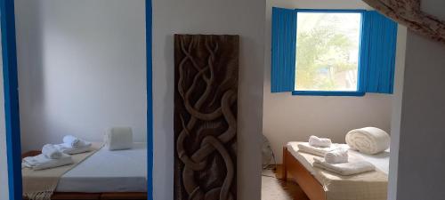 a room with two beds and a mirror on the wall at Casinha do Bem-Viver na Vila de Itaúnas in Itaúnas