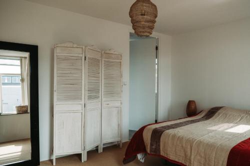a bedroom with a bed and a large window at Bed and Breakfast du Parc in Zaandam