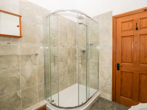 a shower with a glass door in a bathroom at The Barn in Beaminster