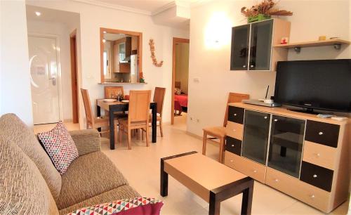 
a living room filled with furniture and a tv at ACV- Cala Blanca II-1ª Linea Planta 4 Norte 2 in Oropesa del Mar
