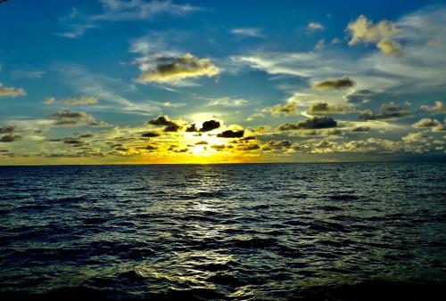 a sunset over a body of water at Sanctum Una Una Eco Dive Resort in Pulau Unauna