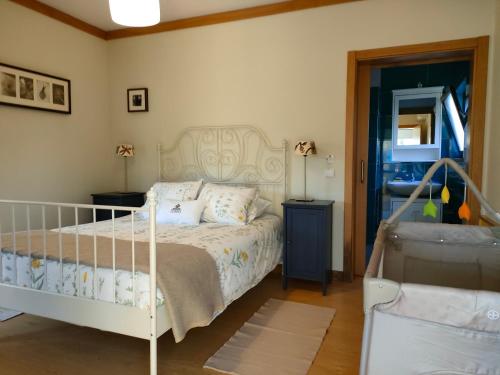 a bedroom with a bed with a white bed frame at Casa Das Palmeiras-Pedagogic Farm in Mangualde