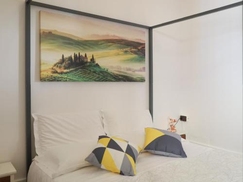 una pintura cuelga sobre una cama con dos almohadas en Firenze Rentals Suite Cavour, en Florencia