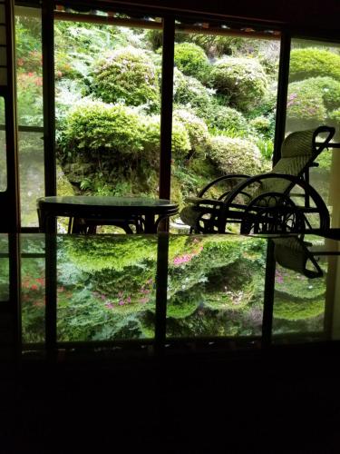 a view of a window with a bench and a garden at 泰山木美山 in Nantan city