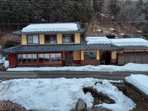 a house on the side of a road with snow at 泰山木美山 in Nantan city