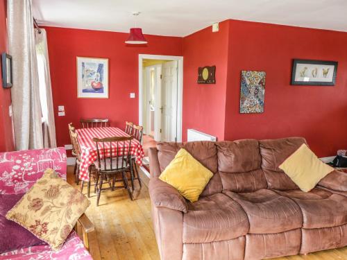 a living room with a couch and a red wall at Errisbeg in Clifden