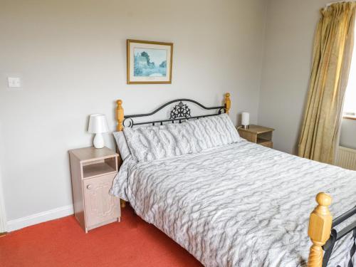 a bedroom with a bed with a white comforter at Errisbeg in Clifden