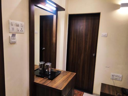 a bathroom with a mirror next to a wooden door at Manasi Pride in Satara