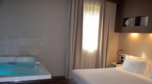 a hotel room with a white bed and white walls at Best Western Plus Hotel Terre di Eolo in Patti