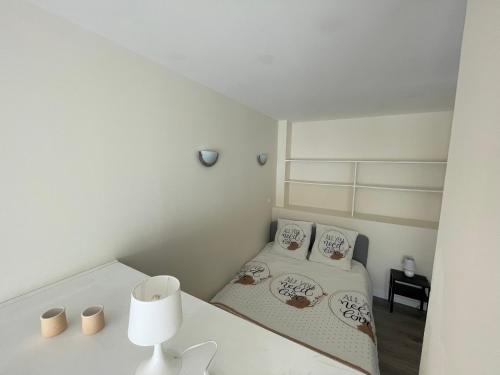 a small white room with two beds in it at JC Appart in Millau