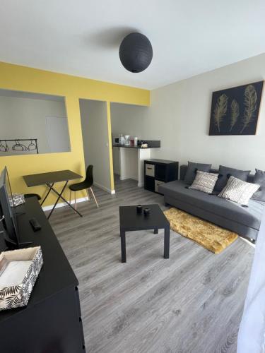 a living room with a couch and a table at JC Appart in Millau