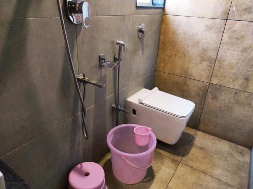 a bathroom with a shower with a toilet and a bucket at Hotel Manasi Royal in Satara