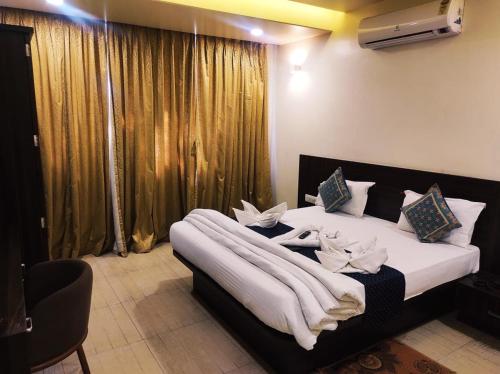 a bedroom with a large bed with white sheets at Hotel Manasi Royal in Satara