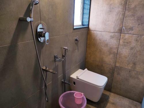 a bathroom with a shower with a toilet and a sink at Hotel Manasi Royal in Satara