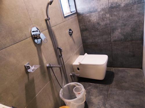 a bathroom with a toilet and a shower stall at Hotel Manasi Royal in Satara