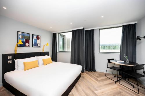 a bedroom with a large white bed and a desk at Staycity Aparthotels Dublin Tivoli in Dublin