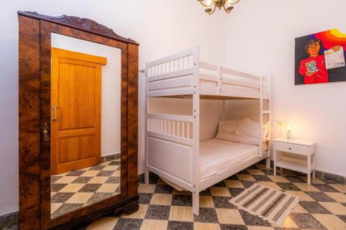 ein Schlafzimmer mit einem Etagenbett mit Leiter in der Unterkunft Cas Padri Teco in Ariany