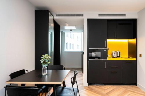 a kitchen and dining room with a table and a yellow cabinet at Staycity Aparthotels Dublin Tivoli in Dublin