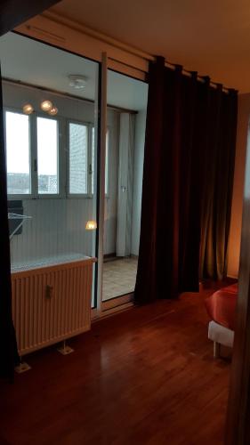 - un salon avec une grande porte en verre et une fenêtre dans l'établissement Près de Melun, Appt 3 pièces 2 chambres tout confort, à Dammarie-les-Lys