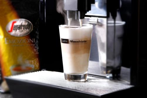 a drink is being made in a coffee machine at Gästehaus Hebinger am Schlosspark in Deidesheim