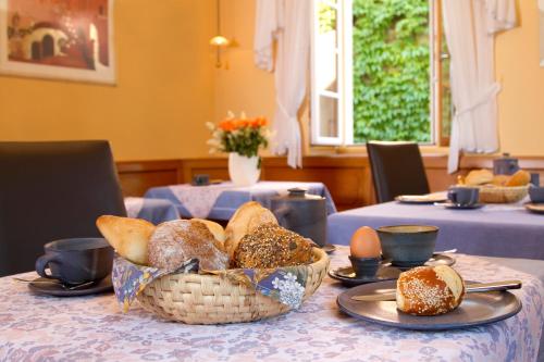 a table with a basket of bread and eggs on it at Gästehaus Hebinger am Schlosspark in Deidesheim